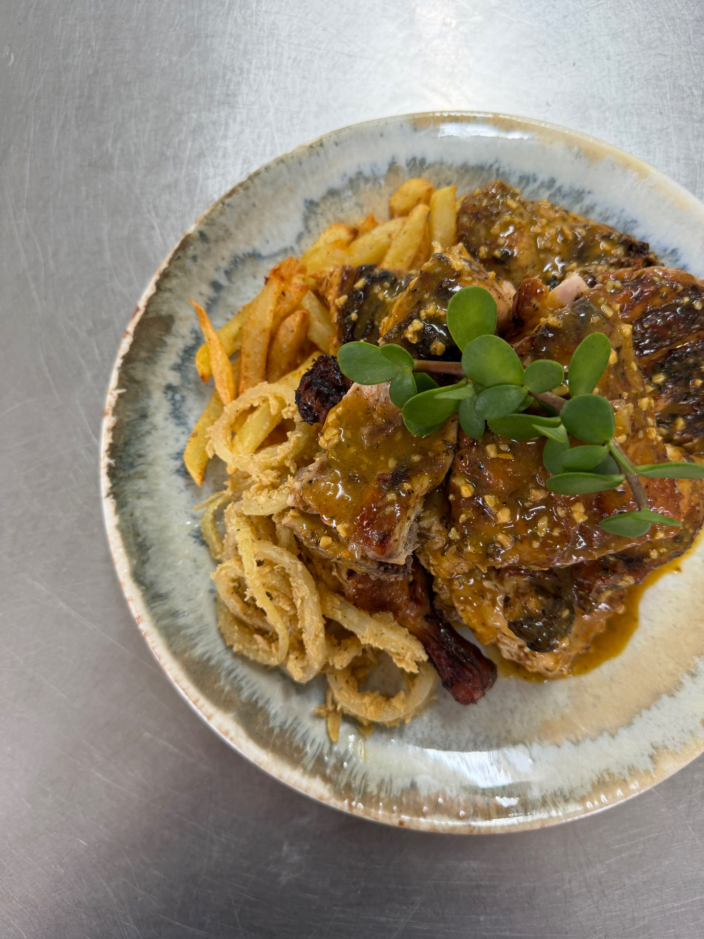 Grilled chicken with peppercorn sauce, onion rings and chips at Lambu Eatery